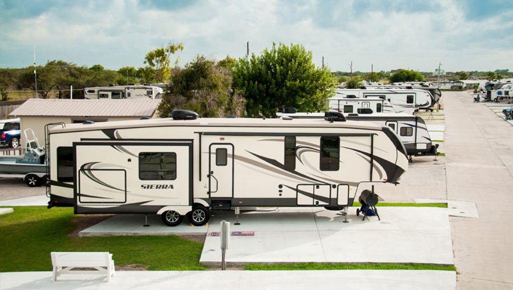 A scenic view of Copano Bay RV Resort in Rockport, TX, featuring multiple recreational vehicles parked in a serene setting.