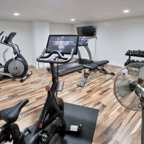 A gym room at Copano Bay RV Resort in Rockport, TX, featuring exercise equipment and a ceiling fan for comfort.