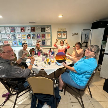 A group of individuals gathered around a table filled with food at Copano Bay RV Resort in Rockport, TX.