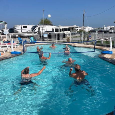 A lively group enjoys a game of volleyball in a pool at Copano Bay RV Resort, Rockport, TX.