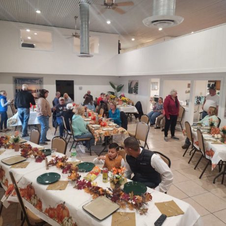 A large group of people seated at tables in a spacious room at Copano Bay RV Resort, Rockport, TX.