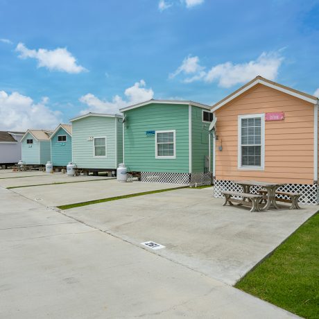 A vibrant row of Cabins lining a street at Copano Bay RV Resort in Rockport, TX.