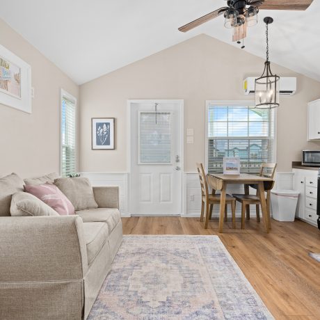 A cozy living room at Copano Bay RV Resort, featuring a couch, table, and a glimpse of the kitchen area.