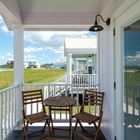 A balcony at Copano Bay RV Resort in Rockport, TX, featuring a table and chairs, perfect for relaxation and views.